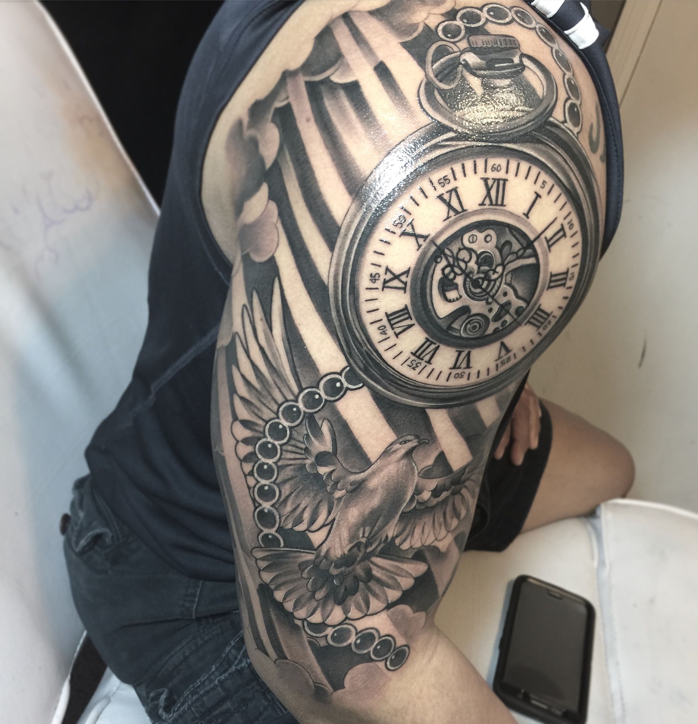 A Man S Arm With A Clock And Skull Tattoo On It