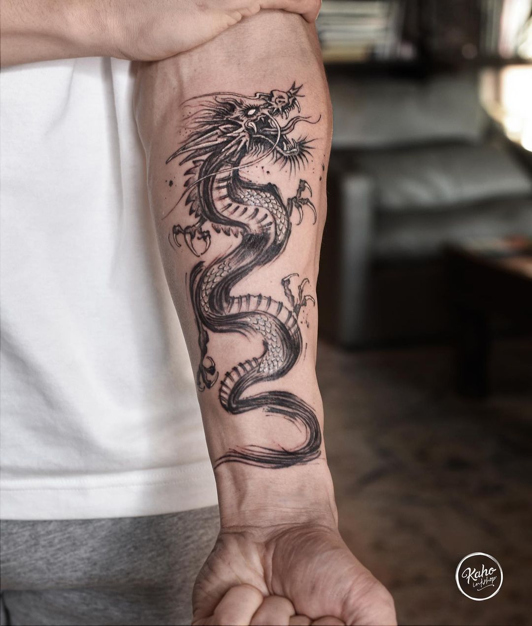 A Man With A Dragon Tattoo On His Arm Holding Onto The Other Side Of