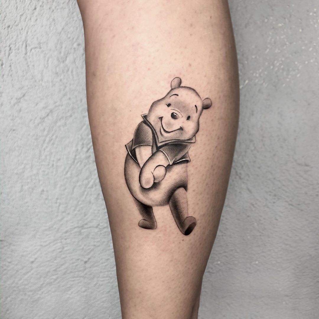 A Winnie The Pooh Tattoo On Someone S Leg With An Orange And Pink Teddy